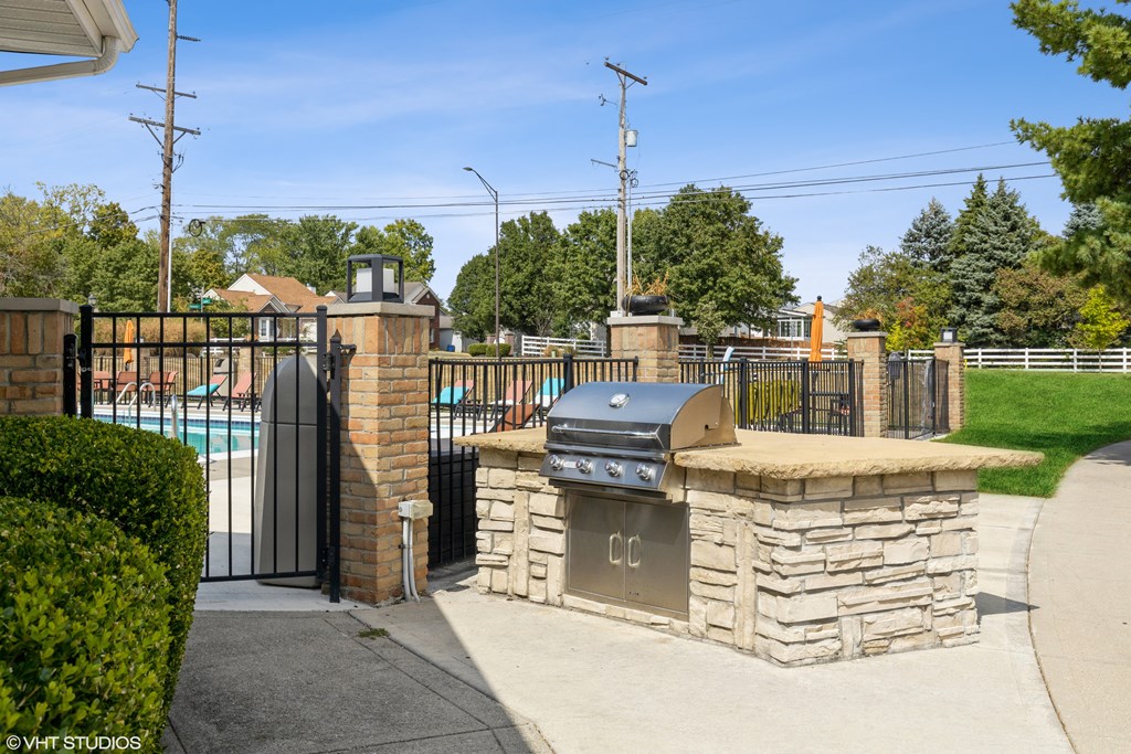 a bbq area with a pool and a wrought iron fence at Springburne at Polaris Apartments, Columbus