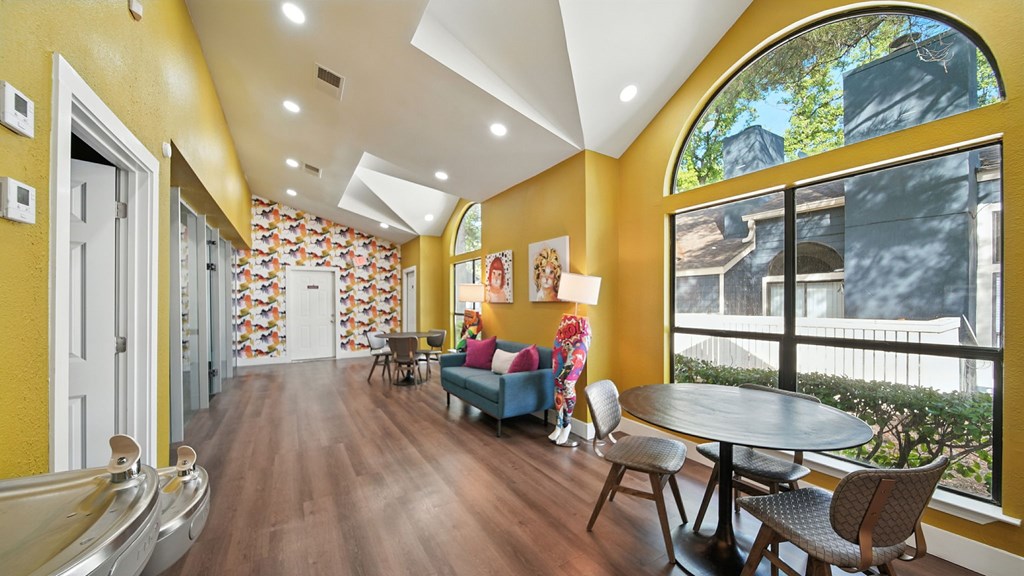 A yellow hallway with a table and chairs.