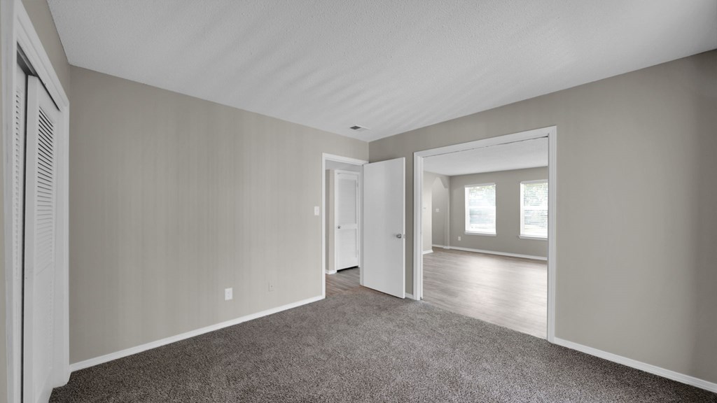 A room with a carpeted floor and a doorway leading to another room. at The Local Apartments, Memphis, TN