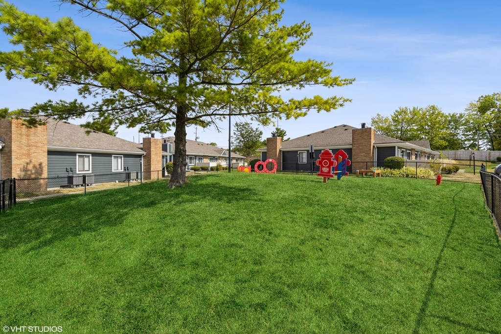 a yard with a playground and houses in the background at Springburne at Polaris Apartments, Columbus, 43235