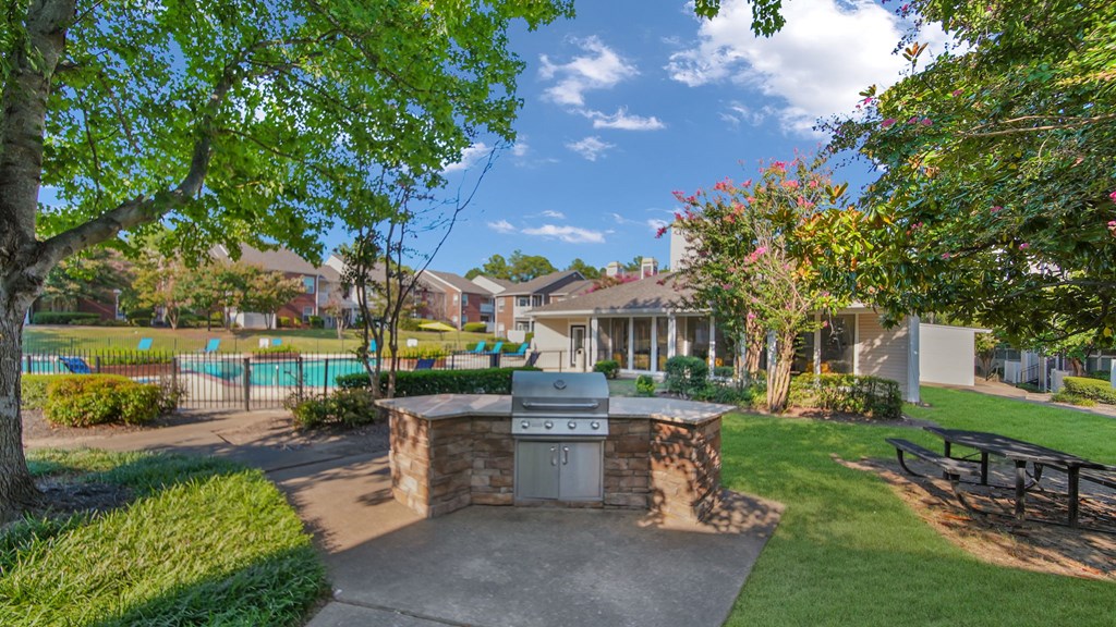 A backyard with a fire pit and a pool in the background.