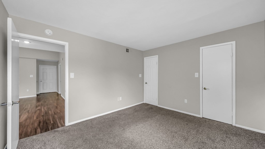 A spacious room with carpeted floor and white walls.
