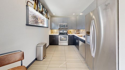 A modern kitchen with stainless steel appliances and a wooden bench.