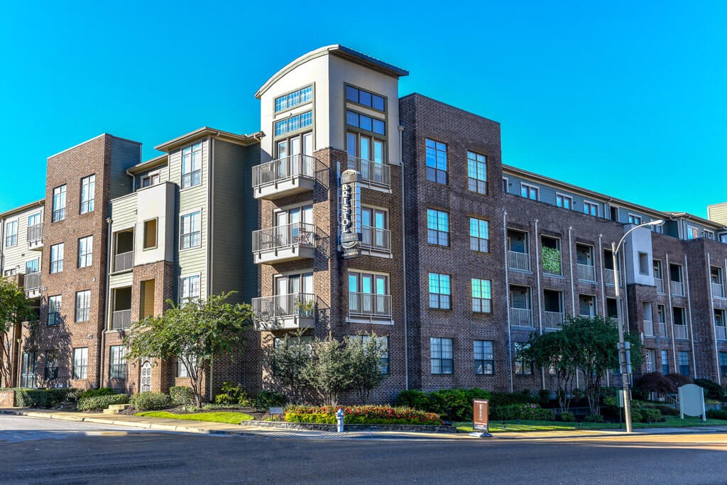 a large apartment building on a street corner