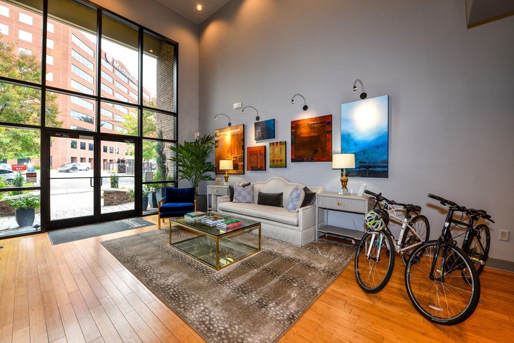 a living room with a couch and two bikes in front of a large window