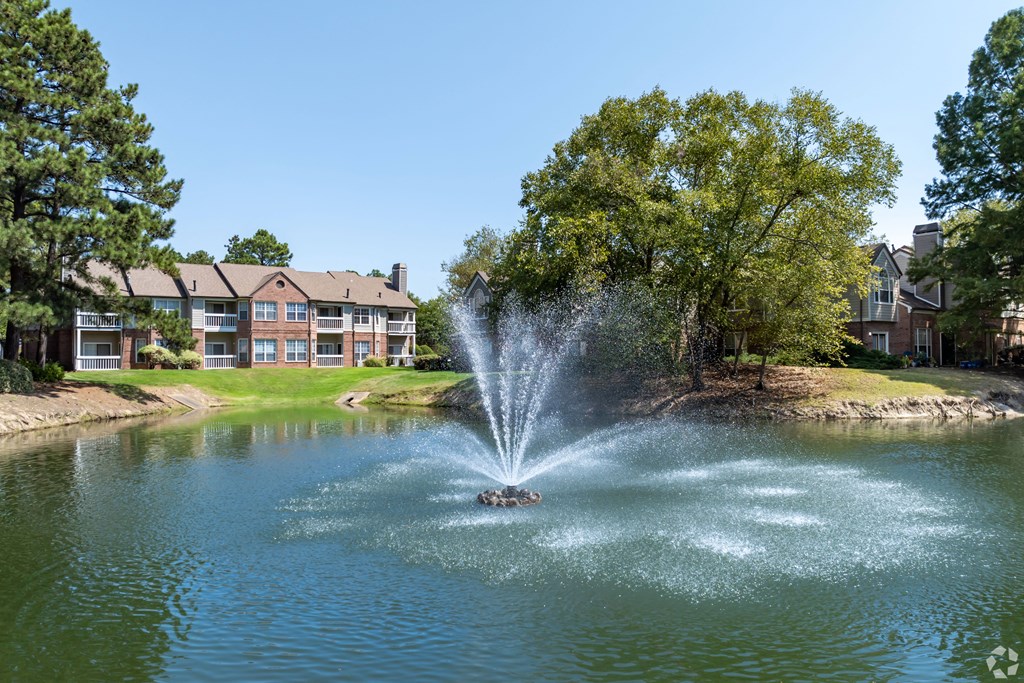 a fountain in the middle of a lake with an apartment building in the background at The Grove Germantown Apartments, Tennessee ?