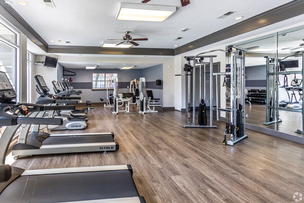 a gym with weights and cardio machines and a ceiling fan at The Grove Germantown Apartments, Germantown, TN 38138 ?