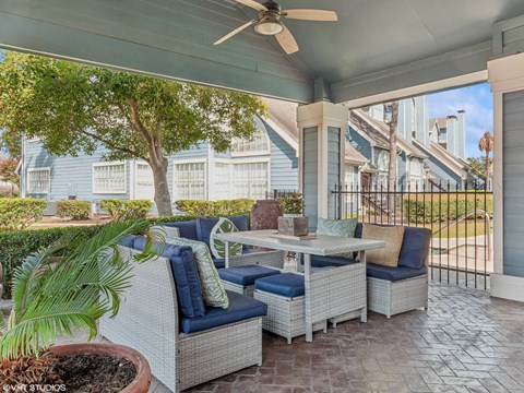 A patio with a table and chairs and a tree.
