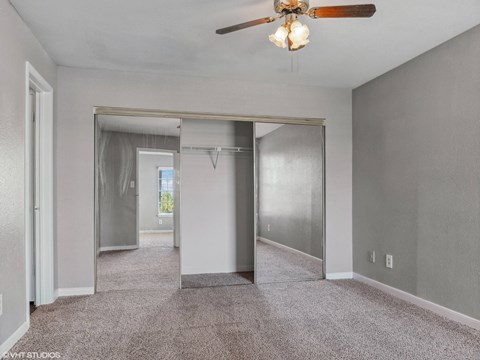 A spacious room with a ceiling fan and a glass door.
