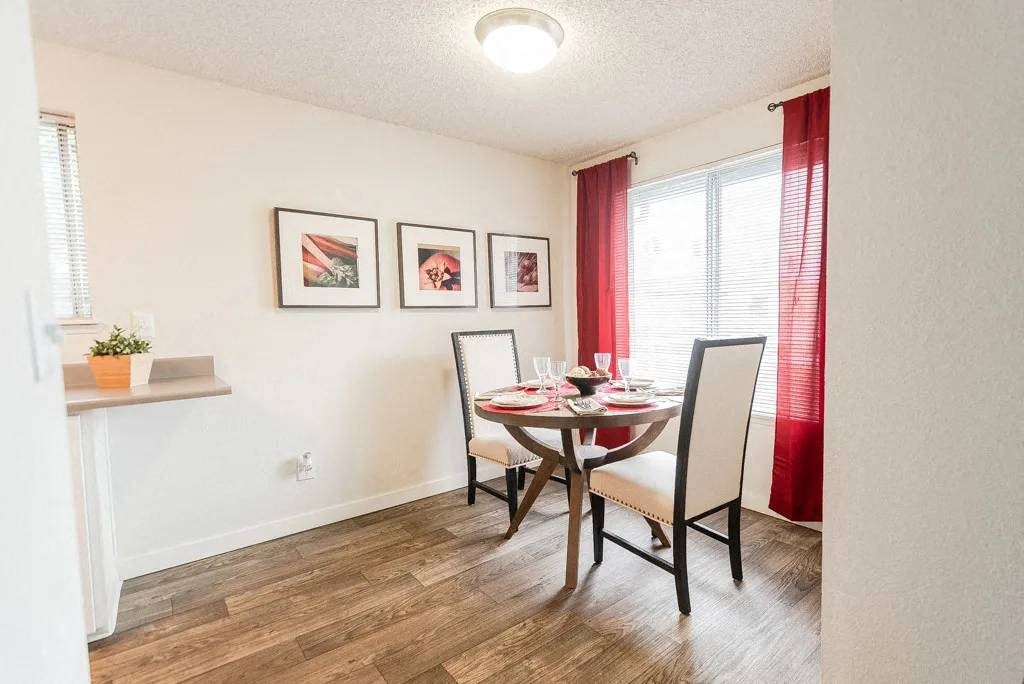A dining room with a table set for two and a potted plant on the windowsill. A dining room with a table set for two and a potted plant on the windowsill at Altitude Apartment , Tacoma