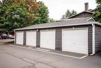 A grey building with three white garage doors at Altitude Apartment , Tacoma