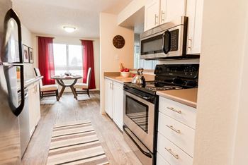 A kitchen with a black stove top oven and a black microwave above it at Altitude Apartment , Tacoma, WA