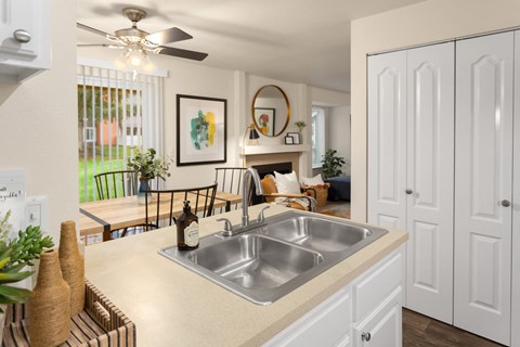 A kitchen with a sink and a fan.