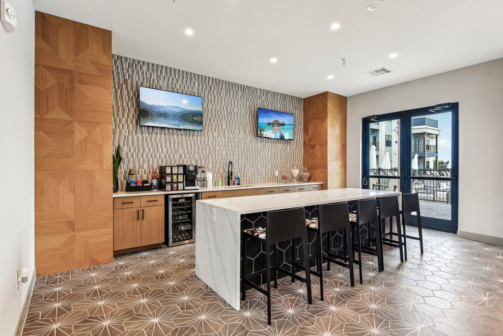a kitchen with a large island and a bar with chairs at The Virginia, Seguin, TX