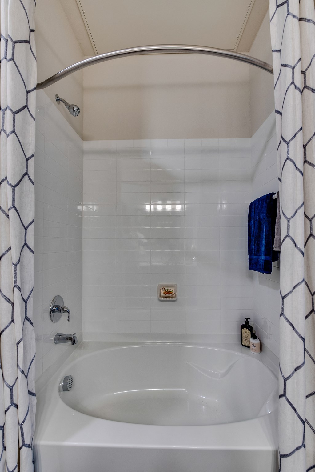 a tub and a shower curtain at The Grand at Stonecreek, Texas