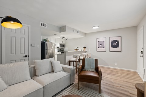 A living room with a grey couch and a brown leather chair.