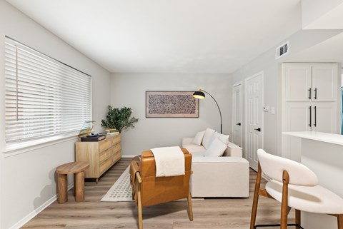 A bedroom with a bed, chair, and a plant.