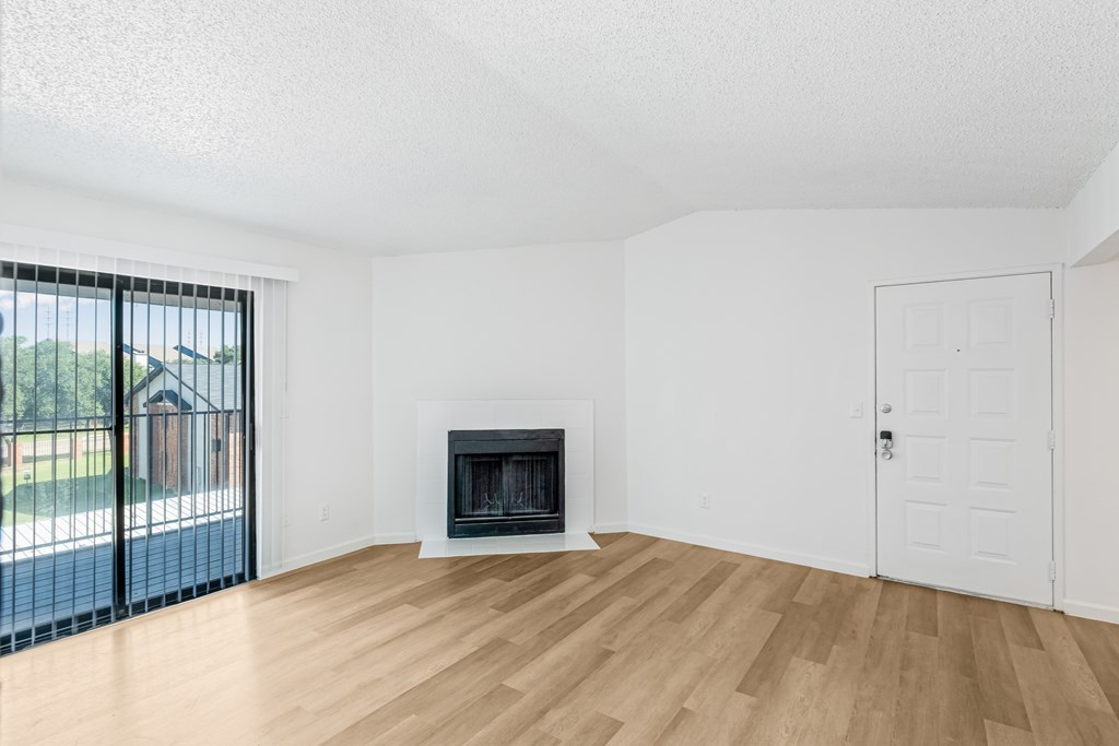 A room with a fireplace and a sliding glass door.