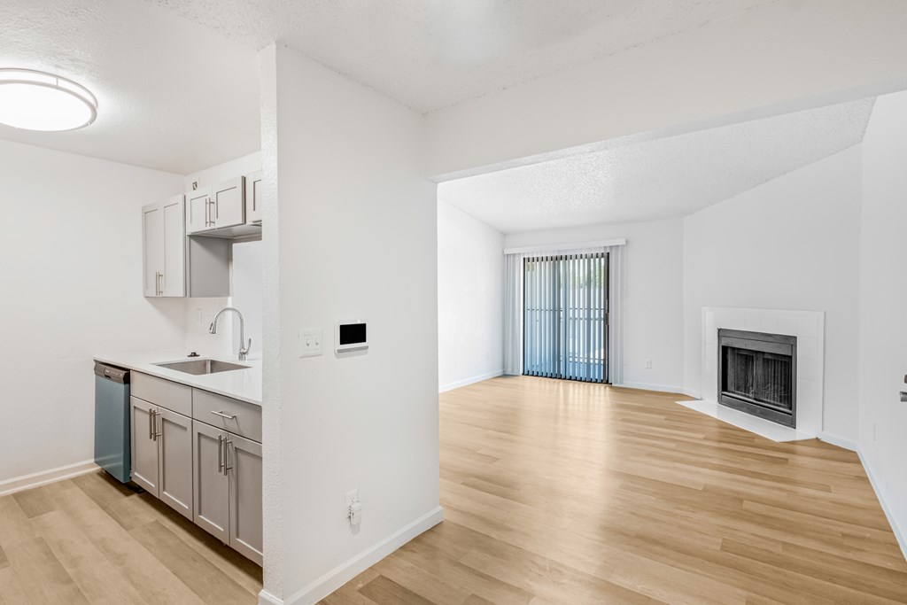 A kitchen with a sink, a refrigerator, and a fireplace.