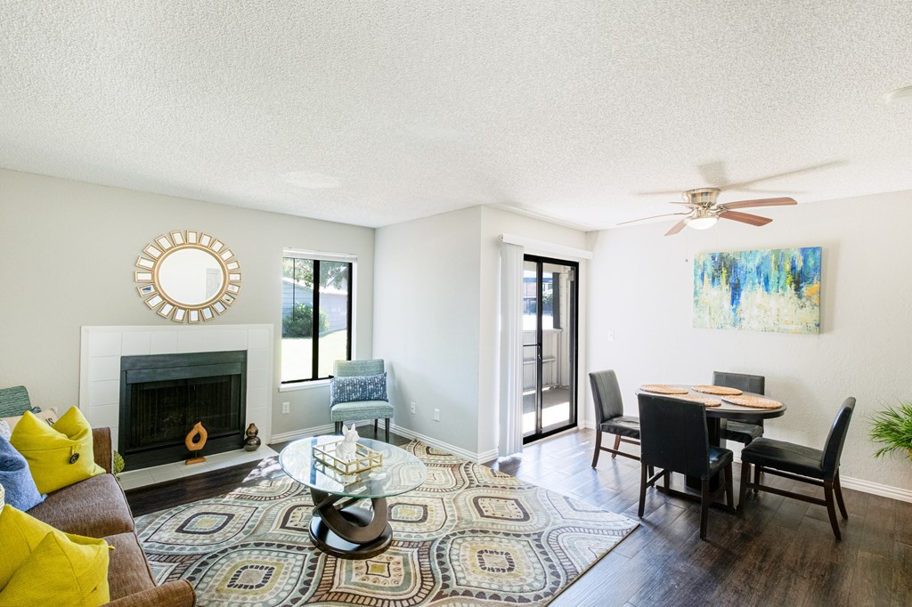 A living room with a fireplace, a dining table, and a rug.
