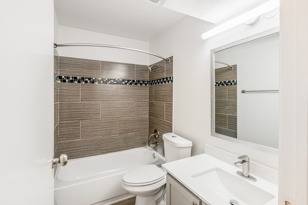 A white toilet sits next to a white sink in a bathroom.
