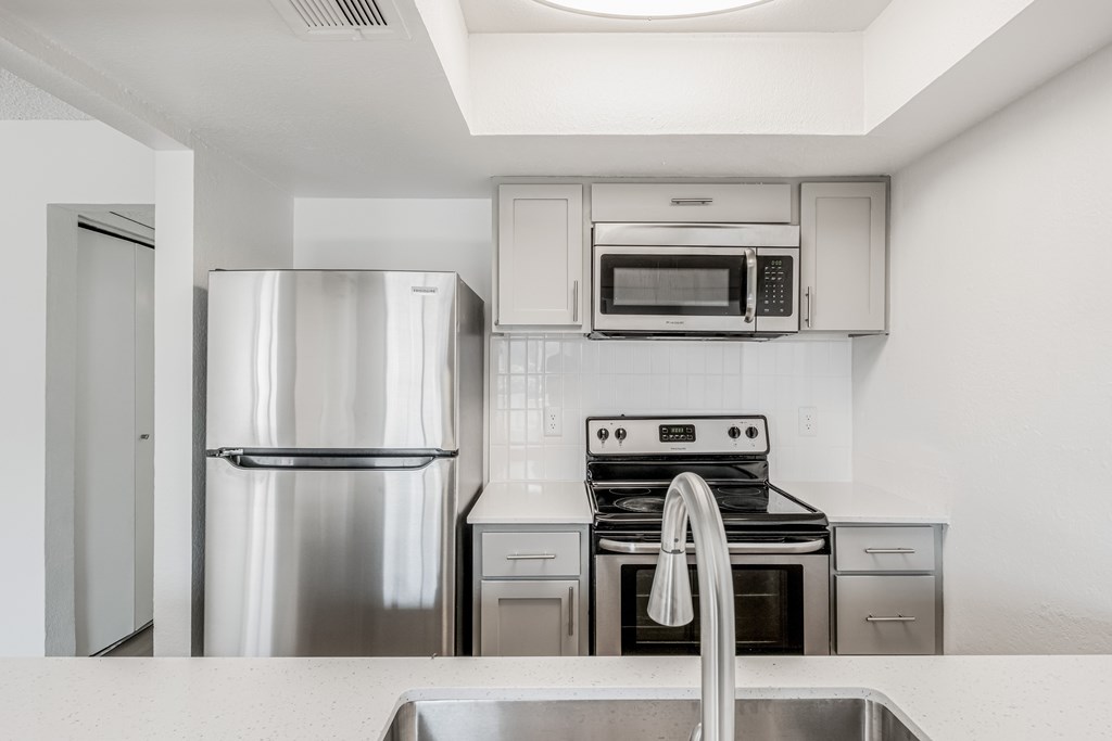 A modern kitchen with stainless steel appliances and white cabinets.