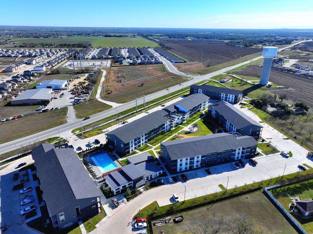 A large building complex with a swimming pool in the middle at The Virginia, Seguin, TX