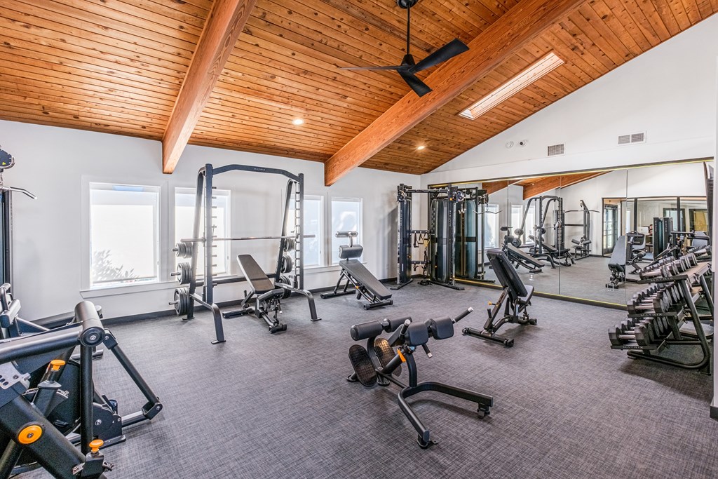 A gym with a variety of equipment including weights and machines.