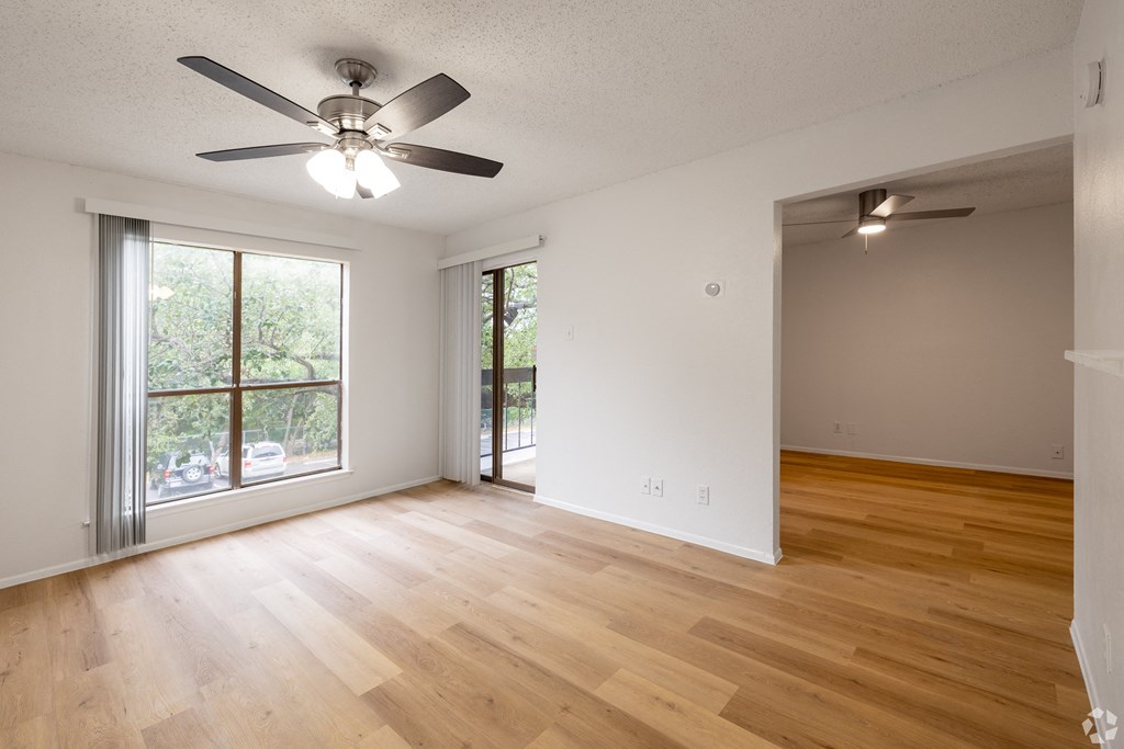 A room with a ceiling fan and wooden flooring. at Sunset Canyon Apartments, San Antonio, TX, 78232