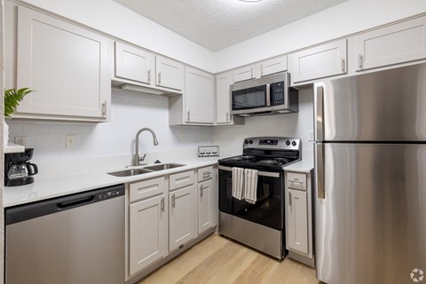A kitchen with white cabinets and stainless steel appliances.