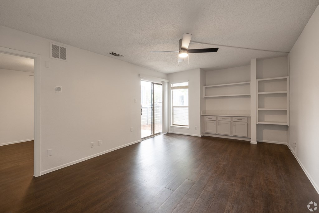 Empty room with wooden floor and white walls at Sunset Canyon Apartments, San Antonio 78232