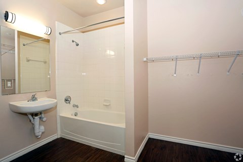 A white sink is on the wall next to a bathtub in a bathroom at Logan Ridge Apartments, San Marcos, TX, 78666