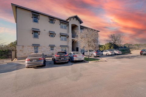 A parking lot with cars and a building in the background.