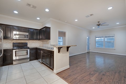 A kitchen with dark wood cabinets and stainless steel appliances.