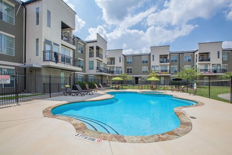 A swimming pool in front of apartment buildings.