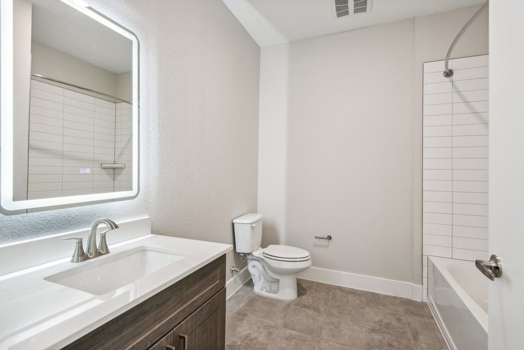 a bathroom with a toilet and a sink and a mirror at The Virginia, Texas