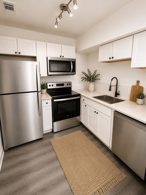 A modern kitchen with a stainless steel refrigerator, microwave, and oven.