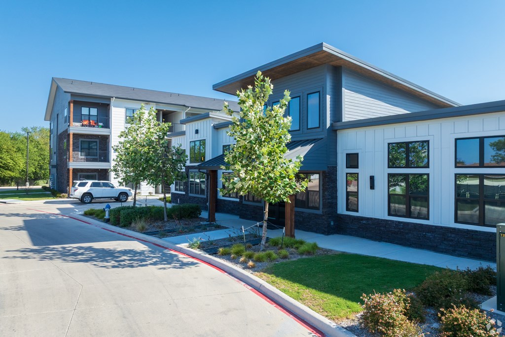 A modern two-story building with a white car parked in front.