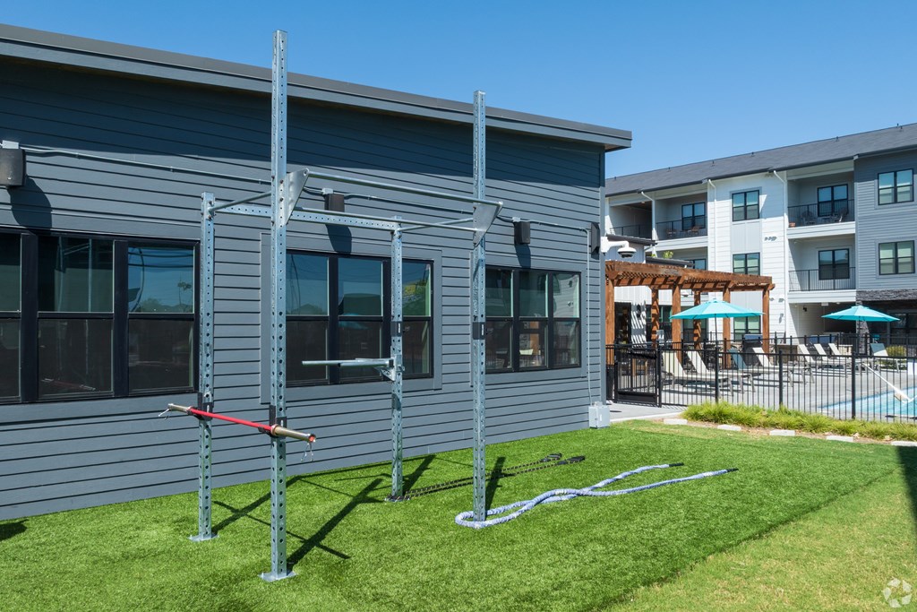 A grey house with a red pole in front of it.