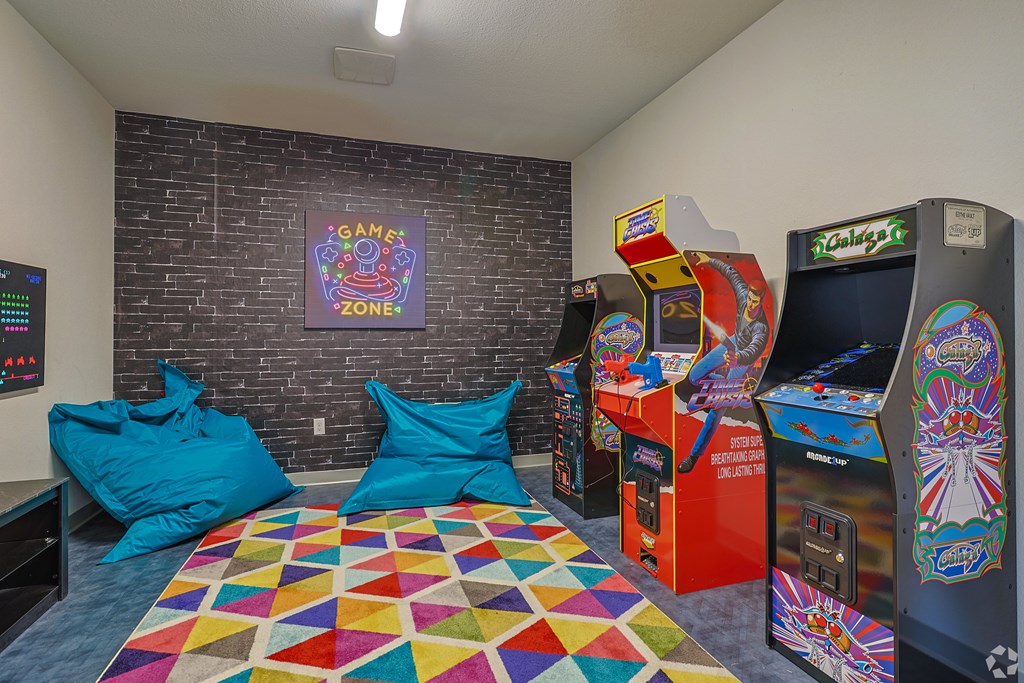 A room with a colorful carpet and a wall with a picture of a game zone.