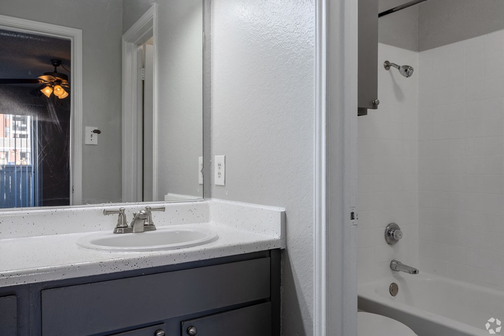 A bathroom with a white sink and a white tub.
