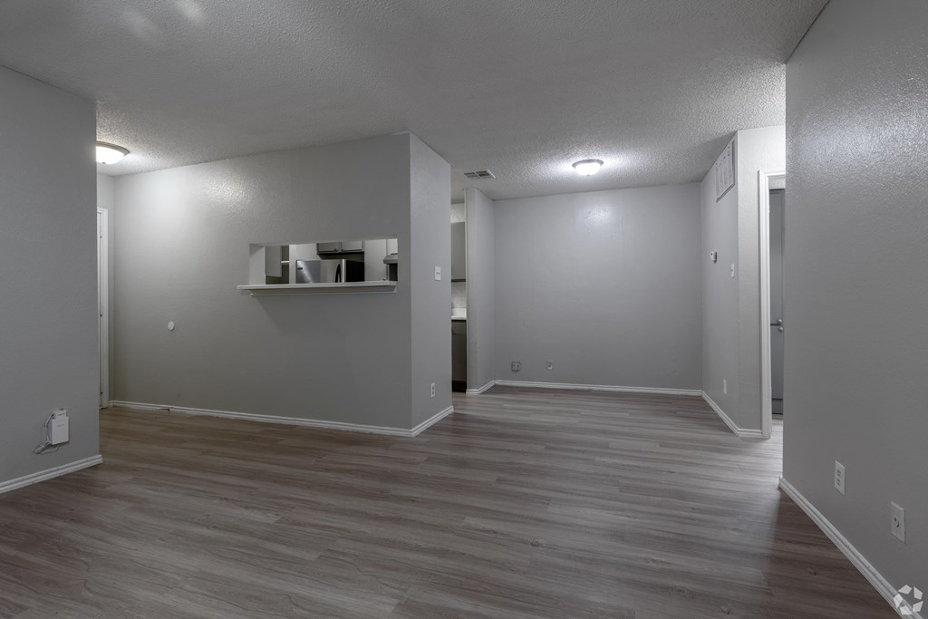 A room with a grey wall and a wooden floor.
