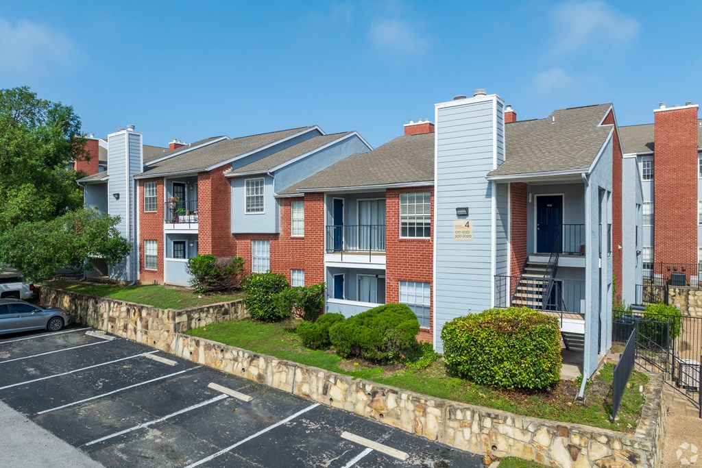 A parking lot in front of a red brick apartment building.