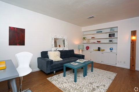 A living room with a grey couch and a white chair.