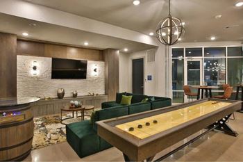a living room with a pool table and a television at The Grand at Stonecreek, San Marcos