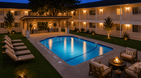 A pool surrounded by chairs and a fire pit in front of a building.