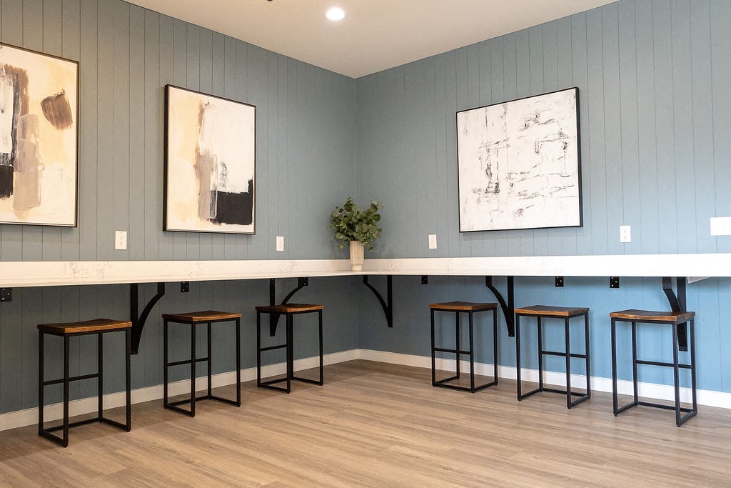 a long table with stools in a room with blue walls and two paintings on the wall  at Sunset Canyon, San Antonio, 78232