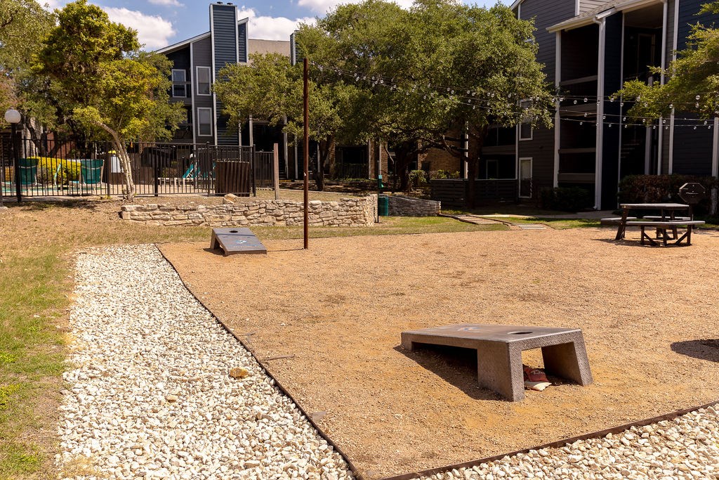 a park with a bench and a table in front of a building  at Sunset Canyon, Texas, 78232