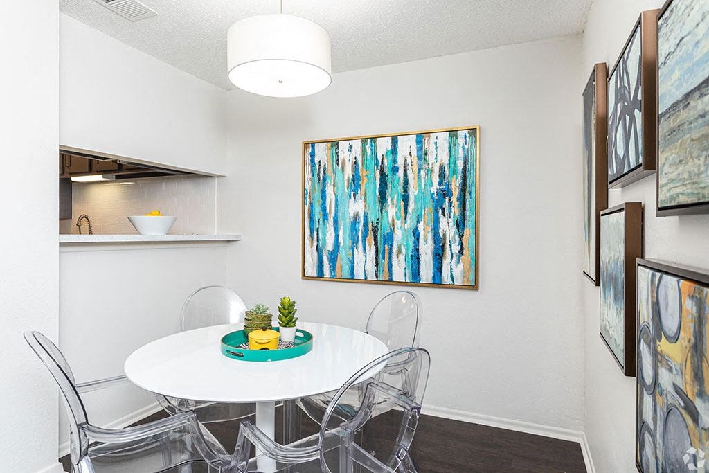 our apartments have a small dining room with a white table and chairs  at Sunset Canyon, San Antonio, TX