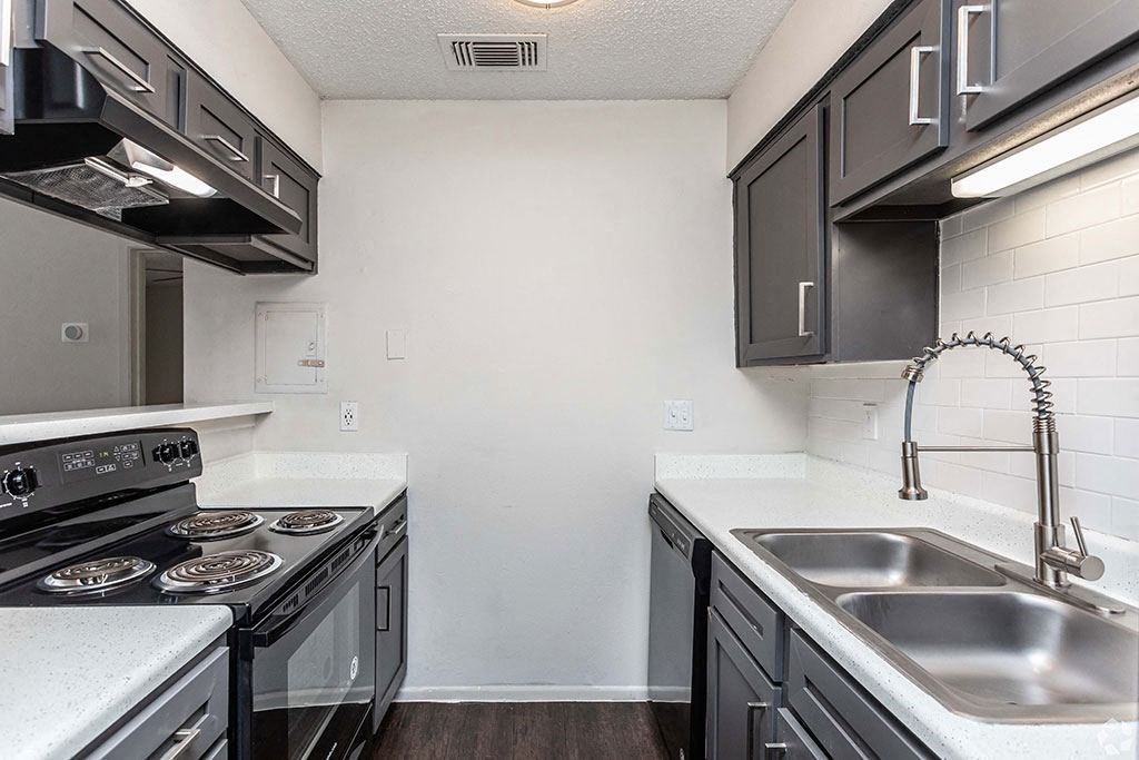 a kitchen with a stove top oven next to a sink  at Sunset Canyon, San Antonio, Texas